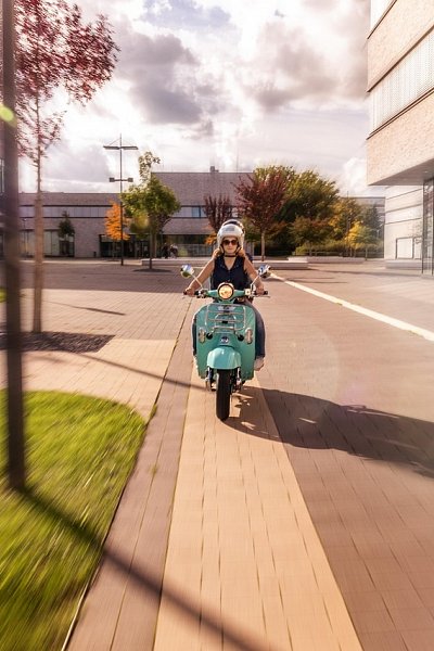 Woman riding rental scooter in Paphos city – long-term scooter hire by Rentamania